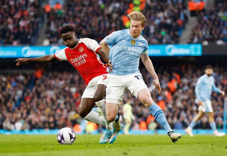Soccer Football - Premier League - Manchester City v Arsenal - Etihad Stadium, Manchester, Britain - March 31, 2024 Arsenal's Bukayo Saka in action with Manchester City's Kevin De Bruyne Action Images via Reuters/Jason Cairnduff NO USE WITH UNAUTHORIZED AUDIO, VIDEO, DATA, FIXTURE LISTS, CLUB/LEAGUE LOGOS OR 'LIVE' SERVICES. ONLINE IN-MATCH USE LIMITED TO 45 IMAGES, NO VIDEO EMULATION. NO USE IN BETTING, GAMES OR SINGLE CLUB/LEAGUE/PLAYER PUBLICATIONS.