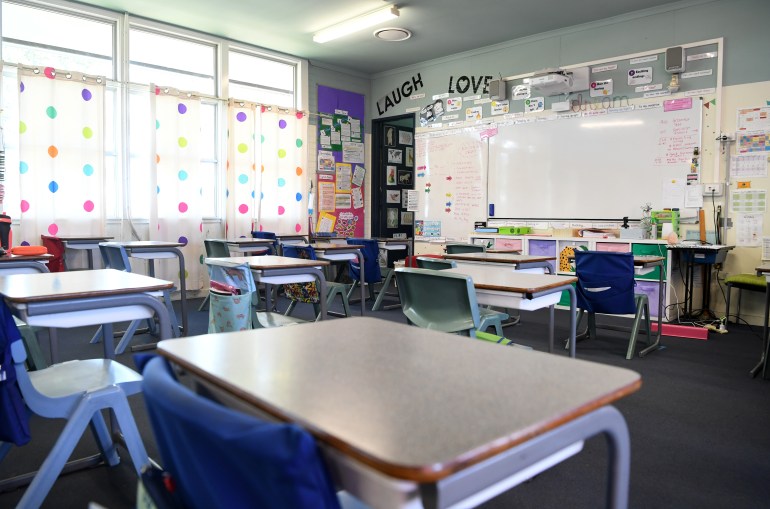 an empty classroom with signs that say 'love' and 'laugh above the white board