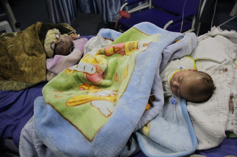  Babies, hospitalized due to malnutrition and dehydration, lie on a hospital bed at Kamal Adwan Hospital in Beit Lahia, Gaza on March 2