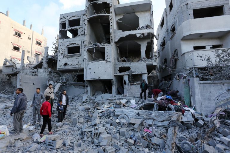 Palestinian residents living in the region examine the destroyed buildings following an Israeli attack on Al-Batran family's building at al-Nuseirat Refugee Camp in Deir al-Balah