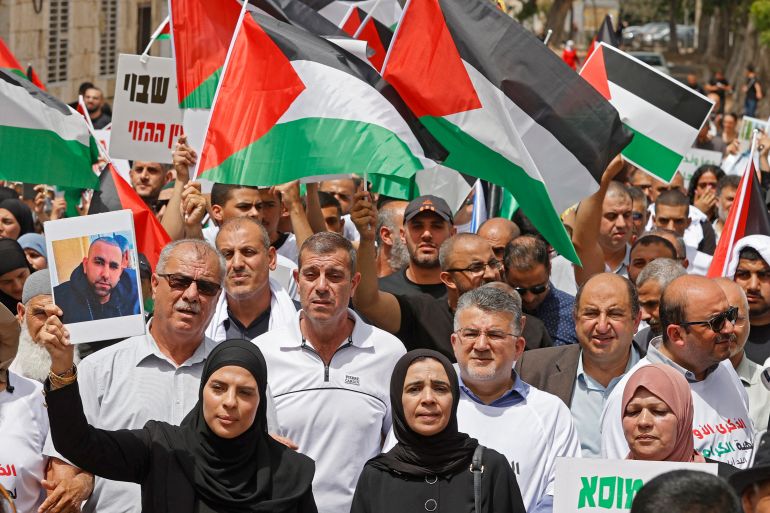 Arab Israelis rally with Palestinian flags in the mixed city of Lod near Tel Aviv on May 13, 2022, a year after a member of their community was killed during intercommunal violence. (Photo by JACK GUEZ / AFP)