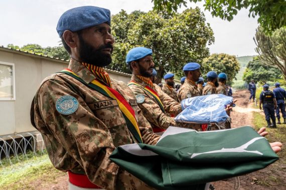 Pakistani peacekeepers hold the Pakistani and UN flags
