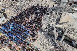 In this aerial view, Palestinians attend Friday noon prayers in front of the ruins of the al-Faruq mosque, destroyed in Israeli strikes in Rafah in the southern Gaza Strip on March 1, 2024 [Said Khatib/AFP]