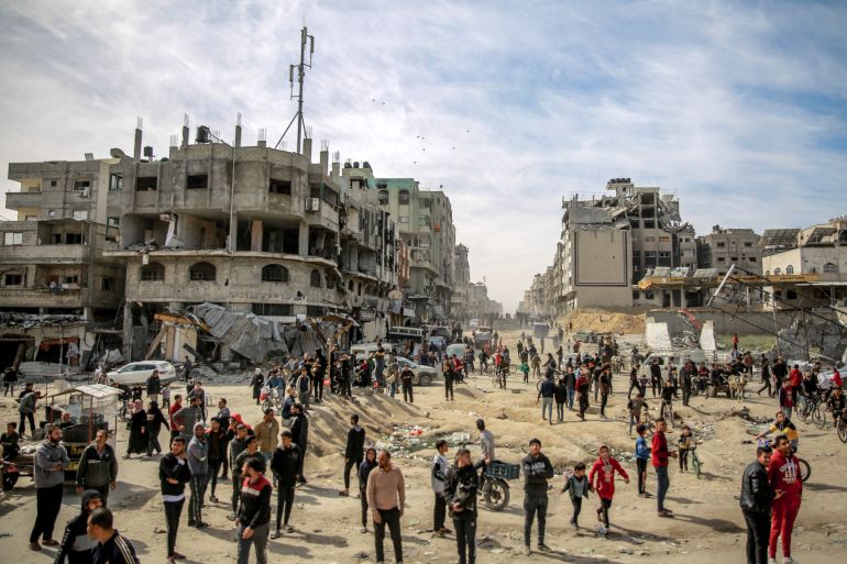 Palestinians gather in a street as humanitarian aid is airdropped in Gaza City on March 1