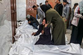 Relatives of Palestinians killed mourn over their bodies at the European hospital morgue in Khan Yunis [Said Khatib/AFP]