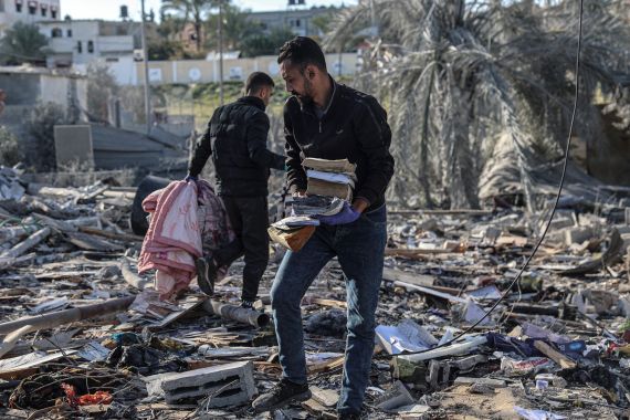 Palestinians search for their belongings amid the rubble of houses destroyed by Israeli bombardment in Rafah in the southern Gaza Strip