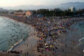 People try to keep cool on Recreio dos Bandeirantes beach on March 17, 2024, during a heatwave in Rio de Janeiro, Brazil. [Tercio Teixeira/AFP]