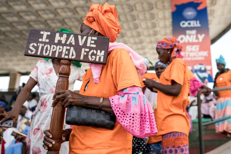 A anti Female Genital Mutilation (FGM) protester holds a placard outside the National Assembly in Banjul on March 18, 2024, during the debate between lawmakers on a highly controversial bill seeking to lift the ban on FGM