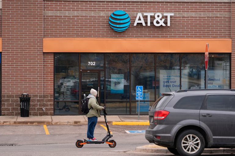 Man on scooter rides past AT&T store in Denver