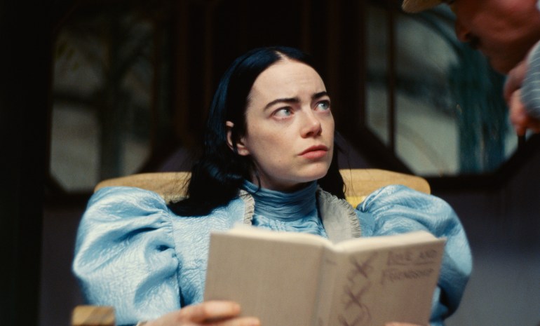 Emma Stone in Poor Things, reading a book