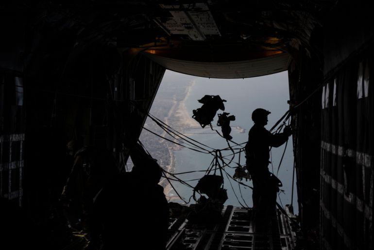 A member of U.S. Air force collects the cables following the parachutes been dropped with humanitarian aid over Gaza Strip, Thursday, March 14, 2024. (AP Photo/Leo Correa)