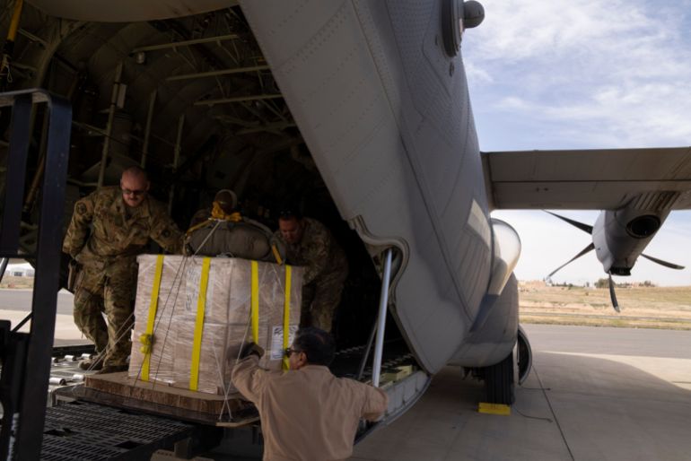 Members of the U.S. Air Force load an airplane prior to drop humanitarian aid over Gaza Strip at an area in Jordan, Thursday, March 14, 2024. (AP Photo/Leo Correa)