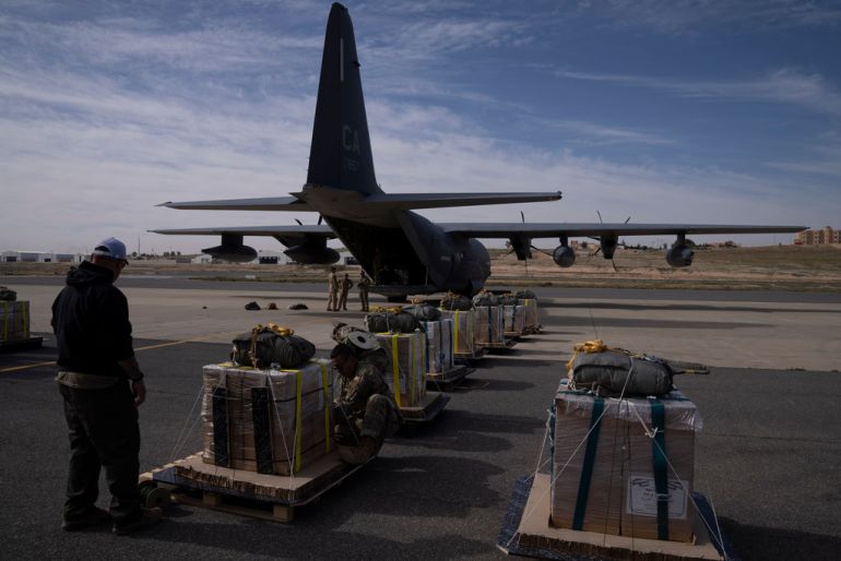 Members of the U.S. Air Force check the containers before loading an airplane with humanitarian aid to be dropped over Gaza Strip at an area in Jordan, Thursday, March 14, 2024. (AP Photo/Leo Correa)