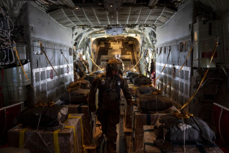 A members of the U.S. Air Force checks the containers with humanitarian aid as he flies toward Gaza Strip after departing from Jordan, Thursday, March 14, 2024. (AP Photo/Leo Correa)