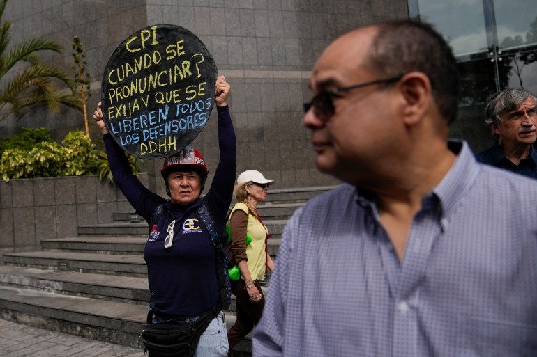 A protester holds up a round sign supporting human rights in Venezuela.