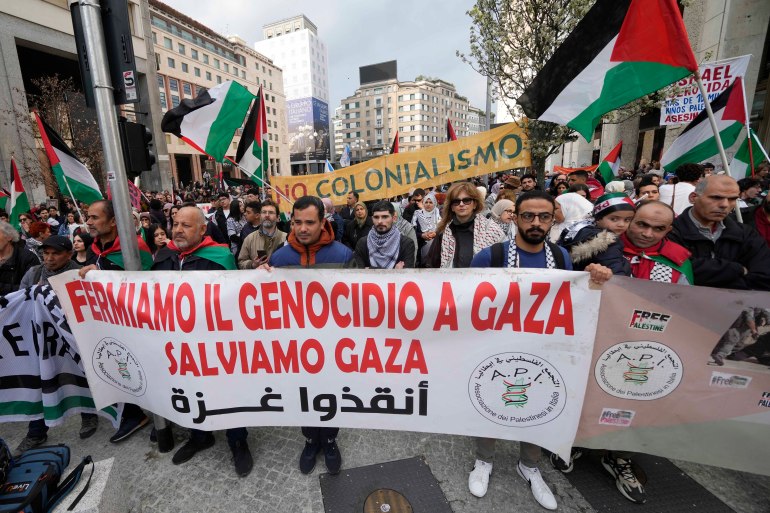 Demonstrators hold a banner reading 'Stop genocide in Gaza, Save Gaza' during a rally in Milan