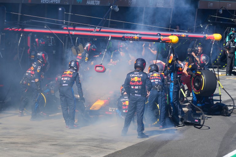 Mechanics work to extinguish a fire in Red Bull driver Max Verstappen of the Netherlands' car during the Australian Formula One Grand Prix at Albert Park, in Melbourne, Australia, Sunday, March 24, 2024. (AP Photo/Scott Barbour,Pool)