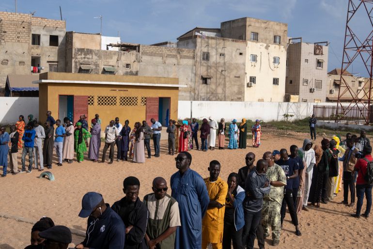 People wait to cast their votes outside a polling station during the presidential elections, in Dakar, Senegal, Sunday, March 24