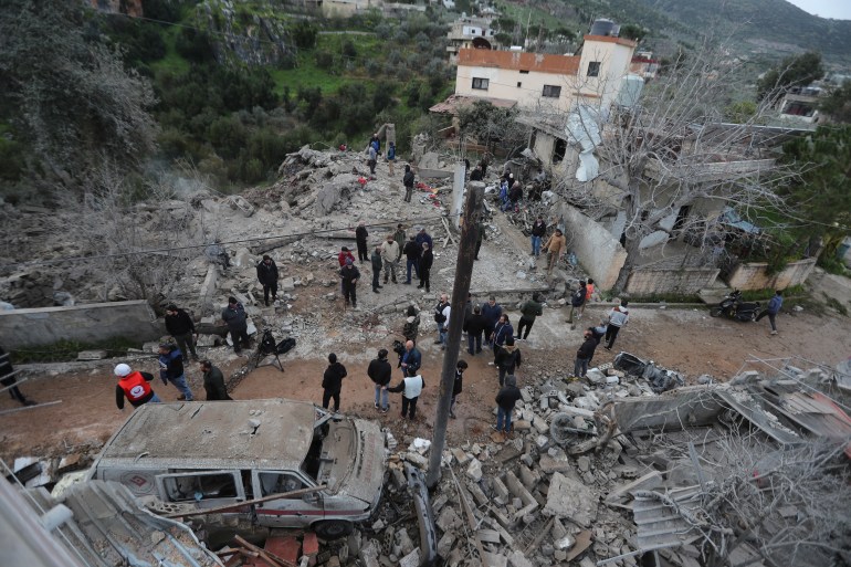 People gather on the rubble of a paramedic center that was destroyed by an Israeli airstrike early Wednesday in Hebbariye village, south Lebanon, Wednesday, March 27, 2024. The Israeli airstrike on a paramedic center linked to a Lebanese Sunni Muslim group killed several people of its members. The strike was one of the deadliest single attacks since violence erupted along the Lebanon-Israel border more than five months ago. (AP Photo/Mohammed Zaatari)
