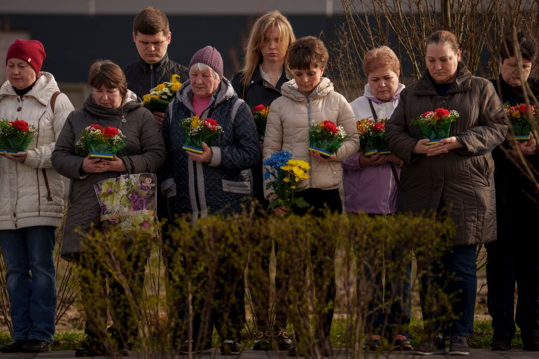 Relatives of those killed during the Russian occupation attend a commemoration for the victims at a cemetery in Bucha, Ukraine