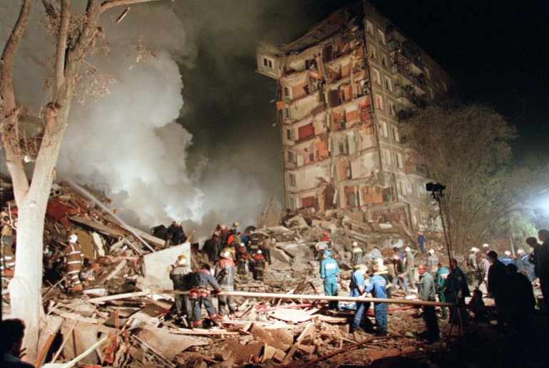 Fire and smoke rises from a destroyed apartment building as Russian Emergency Situations Ministry officers and firefighters try to save people in Moscow, in this Thursday, Sept. 9, 1999 photo as a massive explosion shattered a nine-storey apartment building. Hoping to shame the government into ordering an investigation, a small liberal party on Tuesday showed the Russian premiere of a film alleging the secret service organized four 1999 bombings that helped spark Moscow's second Chechen war and catapault Vladimir Putin to the presidency. (AP Photo/Ivan Sekretarev)