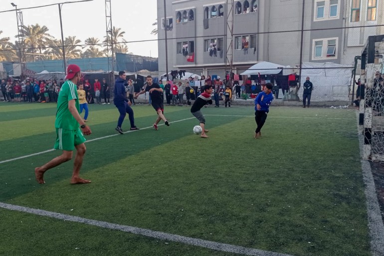 Karam Al-Hwajri (right) reacts to a shot during a Ramadan football tournament at Al-Salah Football Club in Gaza [Abubaker Abed/Al Jazeera]