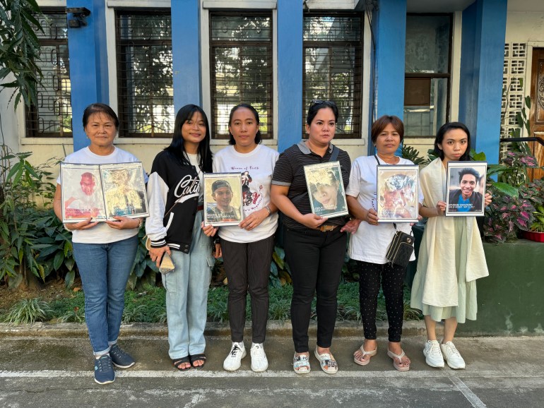 Women from Rise Up. They are holding photos of people killed in the drug war 
