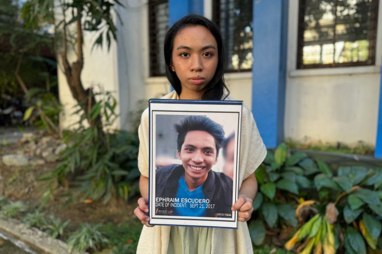 Sheerah Escudero holding a photo of her brother