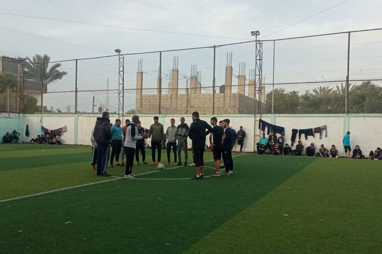 Deux équipes se rassemblent au milieu du terrain avant le début d'un match lors d'un tournoi de football du Ramadan au club de football d'Al-Salah à Gaza (Abubaker Abed/Al Jazeera)