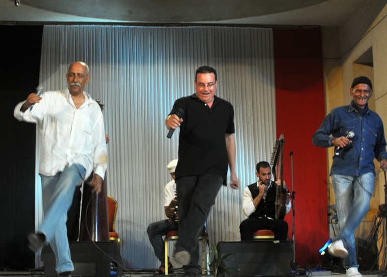 Zakaria dancing with members of his band on stage