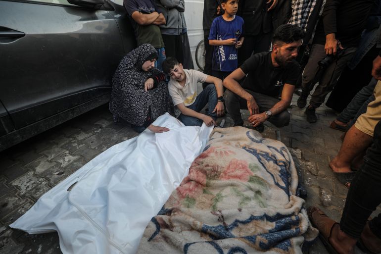 A Palestinian mother mourns over the body of her son at Al Aqsa hospital following an Israeli air strike in the Al Maghazi refugee camp
