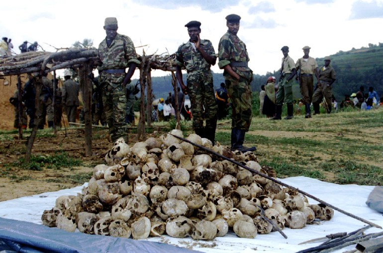 Members of the Rwandan Patriotic Front observe March l9 the skulls of several hundred Tutsi civilians which were dug up and reburied as part of a memorial to approximately 12,000 Tutsi massacred by Hutu militia in and around the western town of Kaduha. The Rwandan government has been performing numerous such reburials as the year anniversary of the beginning of the genocide on April 6th, approaches