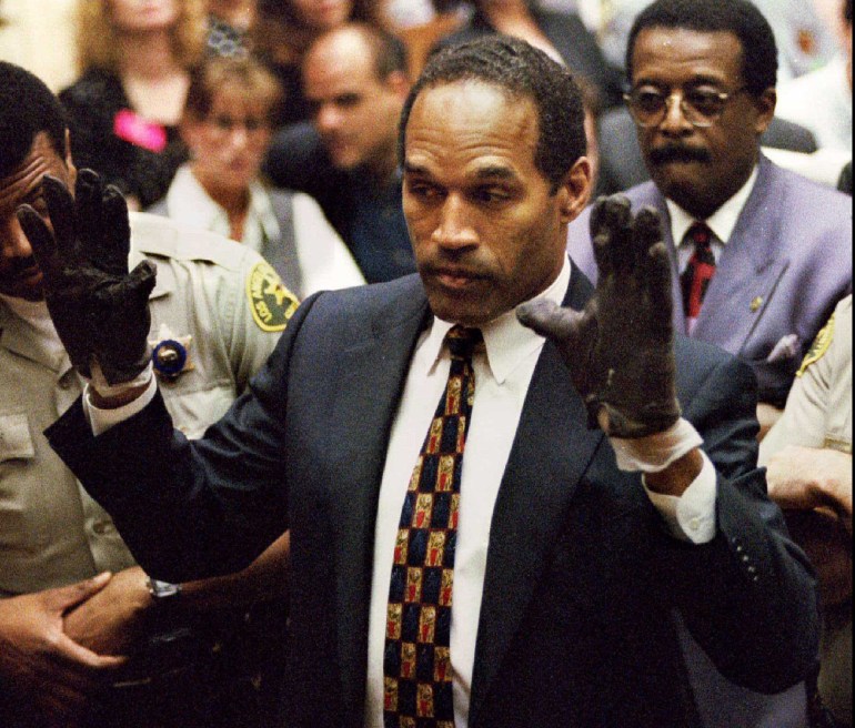 OJ Simpson hält vor Gericht seine Hände hoch, während er schwarze, blutbefleckte Handschuhe trägt.