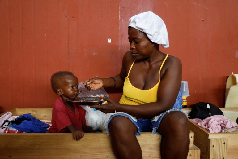 Criança alimentar do Haiti