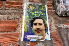 A poster with Pablo Escobar&#039;s image is stuck on a wall in Medellin, Colombia [File: Herbert Villarraga/Reuters]