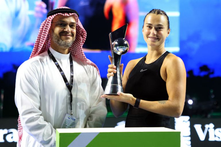 Aryna Sabalenka poses with a trophy alongside Faisal Bafrat, CEO of the the Entertainment Authority Tennis.