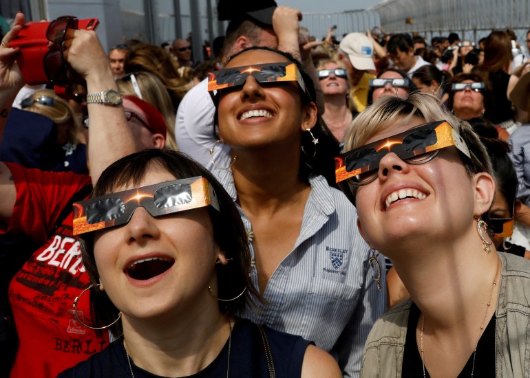 People watch a solar eclipse from New York City
