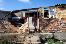 A resident of Diepkloof hostel looks out of a dilapidated building he calls home [File: Siphiwe Sibeko/Reuters]