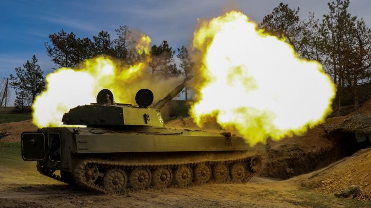 Ukrainian service members of the 37th Marine Brigade fire a 2S1 Gvozdika self-propelled howitzer toward Russian troops
