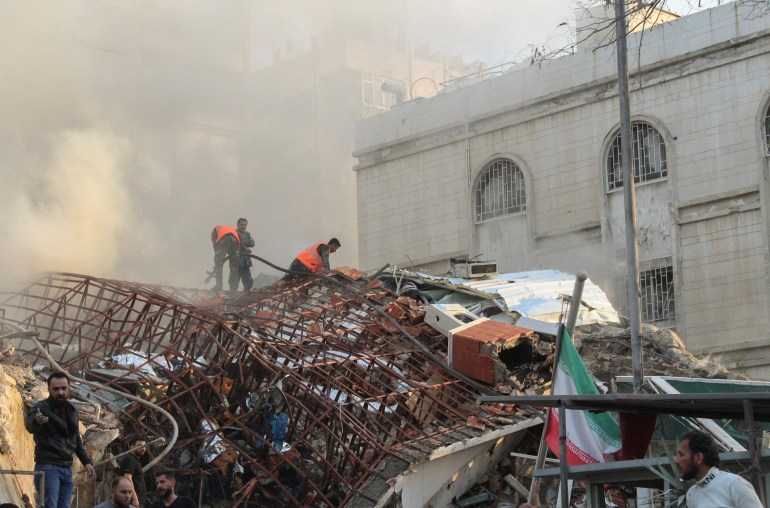 Mitglieder des Zivilschutzes stehen in der Nähe einer beschädigten Stelle nach einem israelischen Luftangriff auf das iranische Konsulat in der syrischen Hauptstadt Damaskus, den syrische und iranische Medien beschrieben