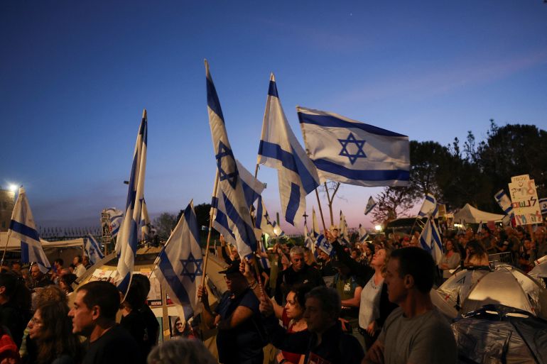 Protesters hold signs and flags, as they demand Israeli Prime Minister Benjamin Netanyahu's ouster, in the wake of the deadly October 7 attack on Israel by the Palestinian Islamist group Hamas and the ensuing war in Gaza, at a demonstration in Jerusalem, April 1, 2024