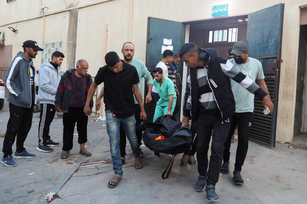 Palestinians carry the body of a foreign employee from the World Central Kitchen (WCK)