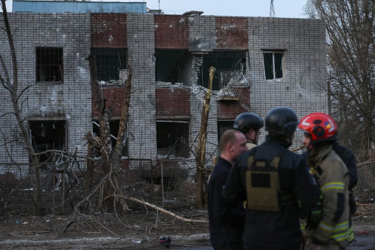 Damaged buildings in Dnipro with emergency workers in front, The facade has been damaged and the windows are missing.