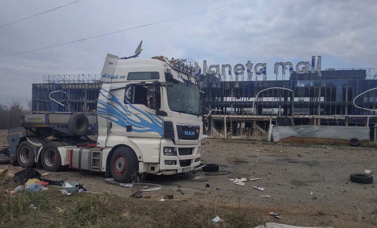Une vue montre un camion et un bâtiment d'un centre commercial endommagés lors de frappes de missiles et de drones russes, au milieu de l'attaque russe contre l'Ukraine, à Kharkiv.
