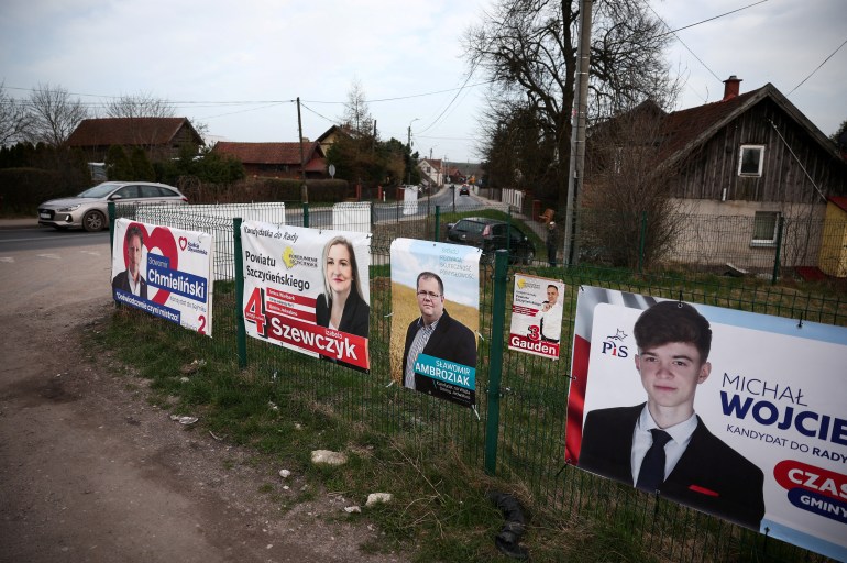 ZDJĘCIE PLIKU: Plakaty wyborcze wiszą na płocie w Jedwabnie w Polsce przed wyborami samorządowymi w Polsce w najbliższy weekend