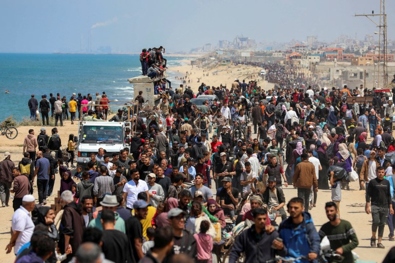 Palestinians, who were displaced by Israel's military offensive on south Gaza, make their way as they attempt to return to their homes in north Gaza, amid the ongoing conflict between Israel and Hamas, as seen from central Gaza Strip 