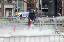 A police officer uses a fire extinguisher as emergency personnel respond to a report of a person covered in flames, outside the courthouse where former U.S. President Donald Trump’s criminal hush money trial is underway, in New York, U.S., April 19, 2024.  REUTERS/Brendan McDermid