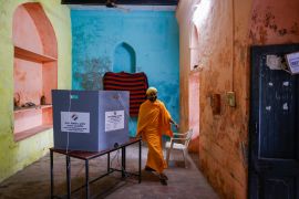 A Hindu holy man, or a Sadhu, walks at a polling station during the second phase of the general election in Vrindavan [Anushree Fadnavis/Reuters]