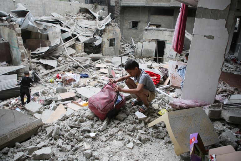 Palestinian children inspect the site of an Israeli strike on a house