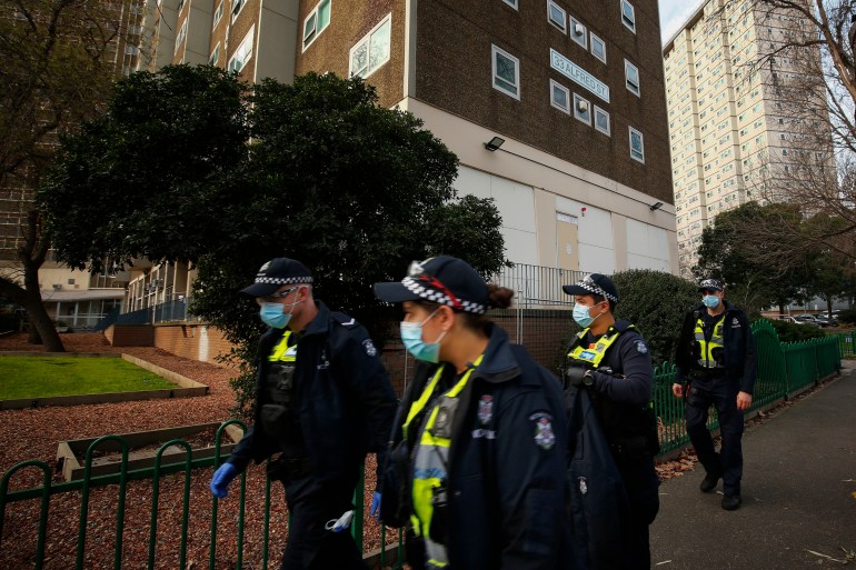 Police patrolling outside the public housing towers during the COVID-19 lockdown. The officers are wearing face masks.